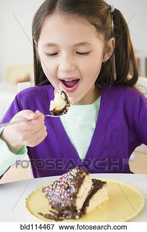 Mixed race girl eating cake View Large Photo Image Stock Photo - Mixed race girl eating cake. Fotosearch