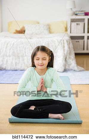 Mixed race girl meditating on yoga mat View Large Photo Image Stock Image - Mixed race girl meditating on yoga mat. Fotosearch