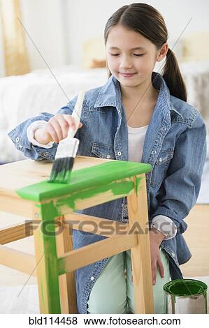 Stock Photo - Mixed race girl painting stool. Fotosearch