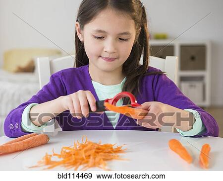 Stock Photo - Mixed race girl peeling carrots. Fotosearch