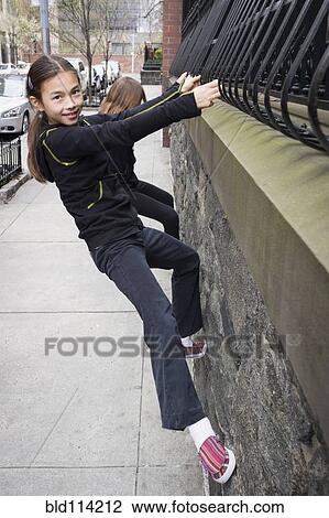 Stock Image - Mixed race girl playing on city street. Fotosearch