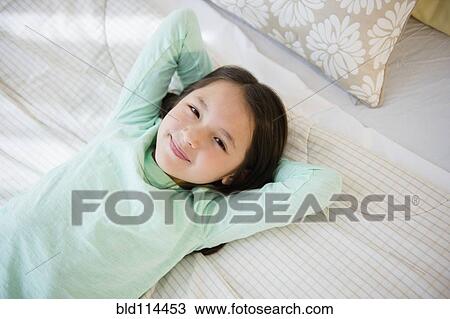 Mixed race girl smiling on bed View Large Photo Image Stock Image - Mixed race girl smiling on bed. Fotosearch