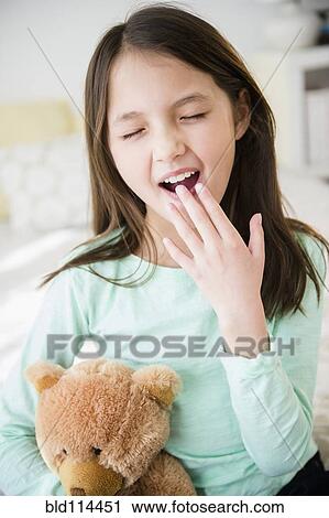 Mixed race girl with teddy bear yawning View Large Photo Image Stock Image - Mixed race girl with teddy bear yawning. Fotosearch