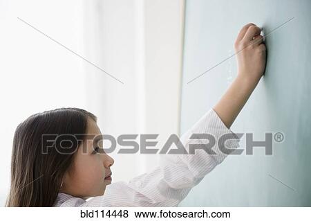 Stock Photo - Mixed race girl writing on chalkboard. Fotosearch