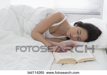 Stock Photography - Mixed race woman asleep in bed. Fotosearch