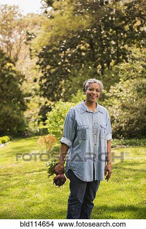 Mixed race woman gardening outdoors View Large Photo Image Picture - Mixed race woman gardening outdoors. Fotosearch
