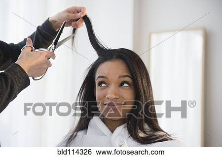 Stock Photograph - Mixed race woman getting hair cut. Fotosearch