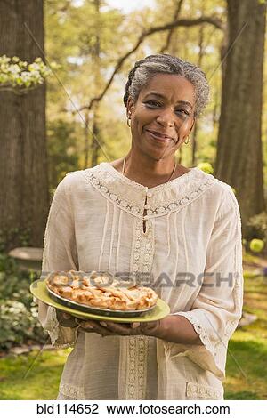 Mixed race woman holding fruit pie outdoors View Large Photo Image Stock Image - Mixed race woman holding fruit pie outdoors. Fotosearch