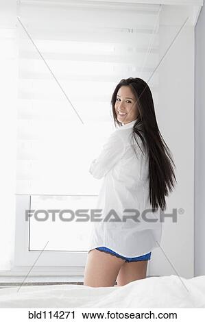 Mixed race woman smiling in bedroom View Large Photo Image Stock Image - Mixed race woman smiling in bedroom. Fotosearch