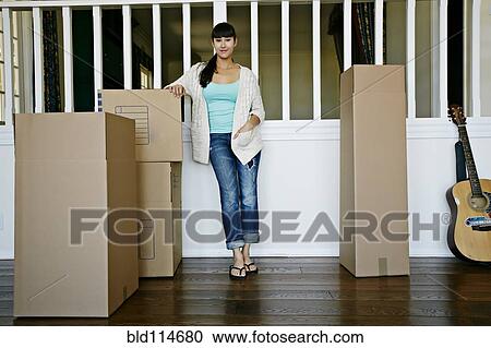 Stock Image - Mixed race woman smiling in new home. Fotosearch