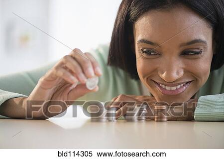 Mixed race woman stacking coins View Large Photo Image Stock Photography - Mixed race woman stacking coins. Fotosearch