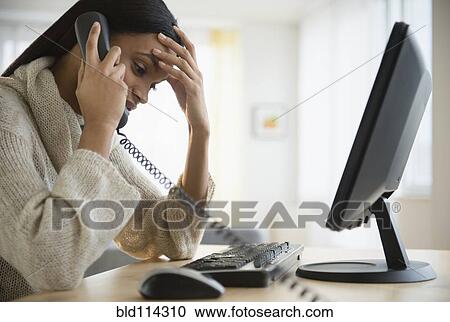 Mixed race woman talking on phone at desk View Large Photo Image Stock Image - Mixed race woman talking on phone at desk. Fotosearch