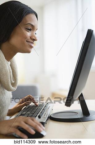 Mixed race woman using computer View Large Photo Image Stock Photo - Mixed race woman using computer. Fotosearch
