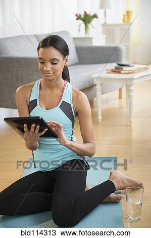 Mixed race woman using tablet computer on yoga mat View Large Photo Image Stock Image - Mixed race woman using tablet computer on yoga mat. Fotosearch