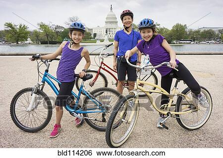 Stock Photograph - Mother and daughters riding bicycles by Capitol Building, District of Columbia, United States. Fotosearch