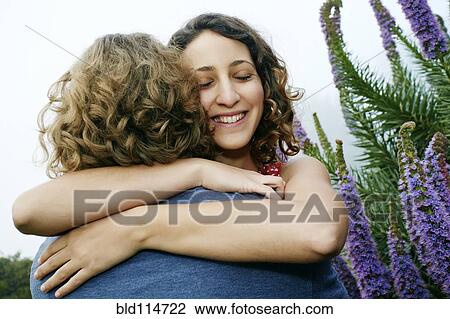 Stock Image - Smiling couple hugging outdoors. Fotosearch
