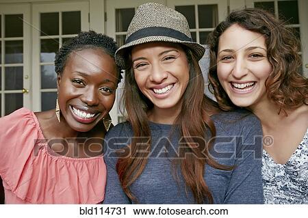 Stock Image - Women smiling together outdoors. Fotosearch