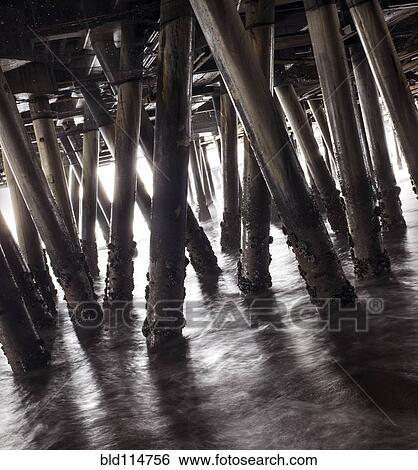 Wooden pillars of boardwalk in waves View Large Photo Image Stock Photograph - Wooden pillars of boardwalk in waves. Fotosearch