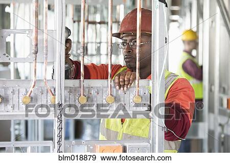 Stock Photo - African American construction worker at construction site. Fotosearch