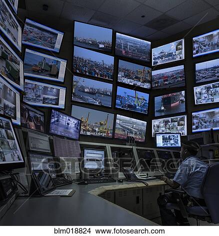 Picture - African American security officer working in control room. Fotosearch