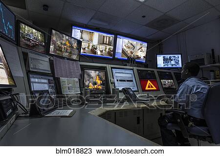 Stock Image - African American security officer working in control room. Fotosearch