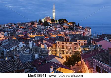 Stock Image - Bell tower and city skyline illuminated at night, Rovinj, Istria, Croatia. Fotosearch