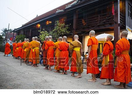 Stock Image - Buddhist monks lined up outside temple, Luang Prabang, Luang Prabang, Laos. Fotosearch