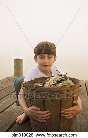 Caucasian boy holding basket of crabs View Large Photo Image Stock Photo - Caucasian boy holding basket of crabs. Fotosearch