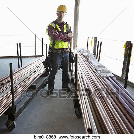 Caucasian construction worker standing with pipes View Large Photo Image Stock Photo - Caucasian construction worker standing with pipes. Fotosearch