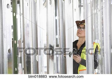 Stock Image - Caucasian construction worker using digital tablet. Fotosearch