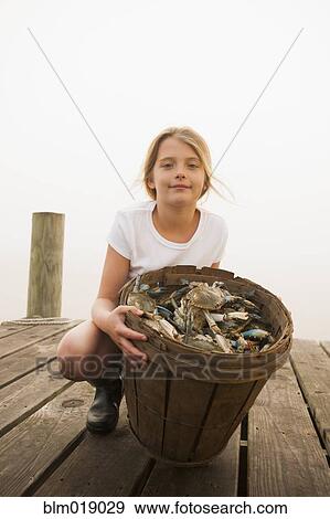 Caucasian girl holding basket of crabs View Large Photo Image Stock Photo - Caucasian girl holding basket of crabs. Fotosearch