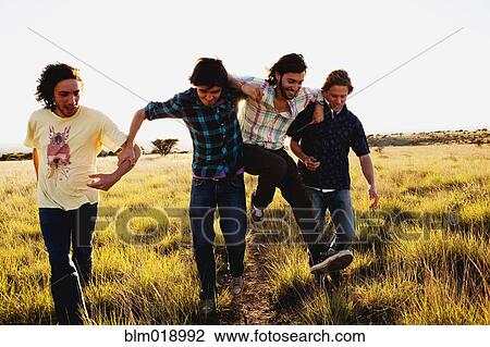 Caucasian men walking together in tall grass View Large Photo Image Stock Image - Caucasian men walking together in tall grass. Fotosearch