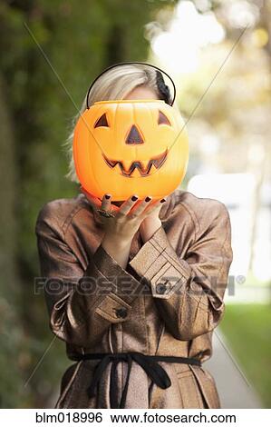 Caucasian woman holding jack o' lantern bucket View Large Photo Image Stock Photograph - Caucasian woman holding jack o' lantern bucket. Fotosearch