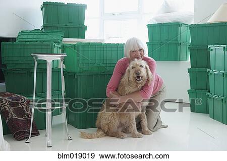 Caucasian woman hugging dog in new home View Large Photo Image Stock Photo - Caucasian woman hugging dog in new home. Fotosearch