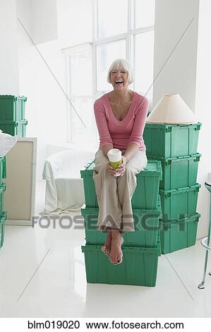 Stock Image - Caucasian woman laughing in new home. Fotosearch