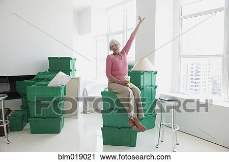 Stock Image - Caucasian woman laughing in new home. Fotosearch