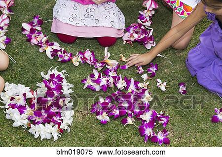 Stock Photography - Children playing with flower leis in grass. Fotosearch