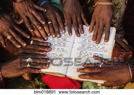 Stock Image - Close up of hands on book at festival, Allahabad, Uttar Pradesh, India. Fotosearch