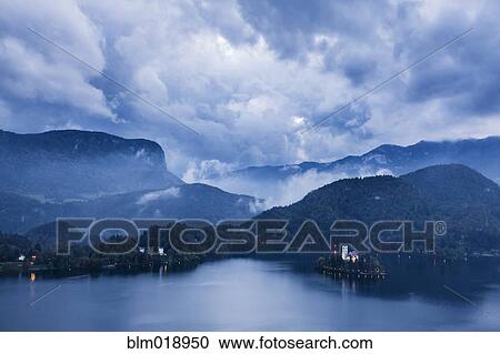 Stock Image - Clouds and mountains over Lake Bled, Slovenia. Fotosearch