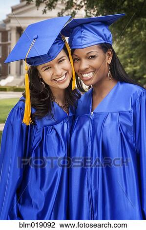 Stock Image - College graduates smiling together. Fotosearch