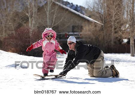 Stock Photo - Father and daughter playing in snow. Fotosearch
