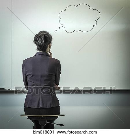 Stock Image - Filipino businesswoman with thought bubble in office. Fotosearch