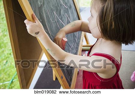 Girl drawing on blackboard easel View Large Photo Image Stock Image - Girl drawing on blackboard easel. Fotosearch