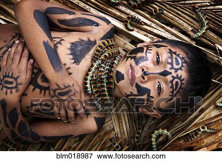 Stock Photo - Hispanic boy with painted body laying on straw, La Coroza, Lago Izabal, Guatemala. Fotosearch