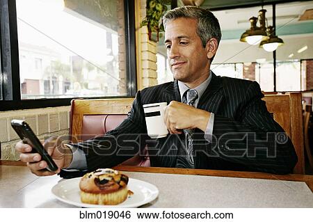 Hispanic businessman using cell phone in restaurant View Large Photo Image Stock Photograph - Hispanic businessman using cell phone in restaurant. Fotosearch