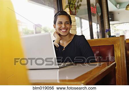 Stock Photograph - Hispanic businesswoman smiling in restaurant. Fotosearch