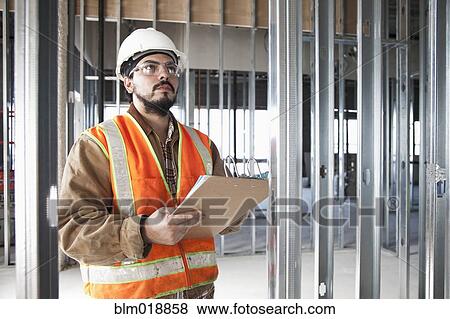 Hispanic construction worker writing on clipboard View Large Photo Image Stock Photo - Hispanic construction worker writing on clipboard. Fotosearch