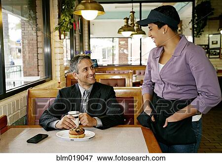 Hispanic waitress talking to businessman in restaurant View Large Photo Image Stock Photo - Hispanic waitress talking to businessman in restaurant. Fotosearch