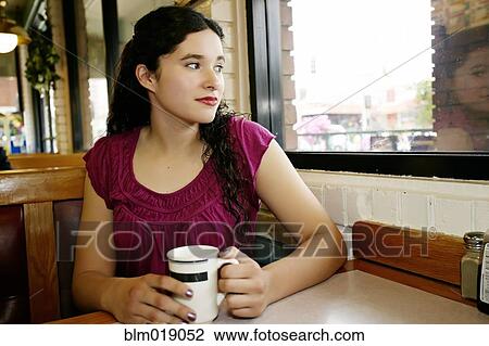 Mixed race woman having coffee in restaurant View Large Photo Image Stock Image - Mixed race woman having coffee in restaurant. Fotosearch