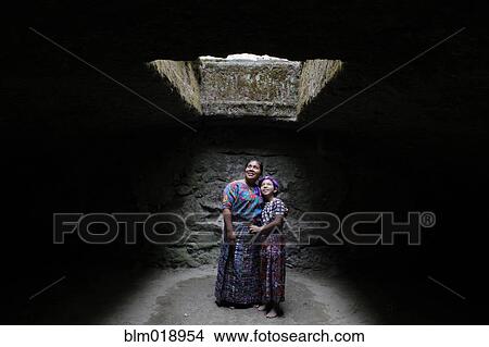 Picture - Mother and daughter standing under skylight. Fotosearch